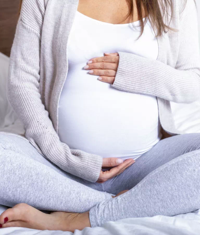 Kobieta w ciąży trzyma się za brzuch